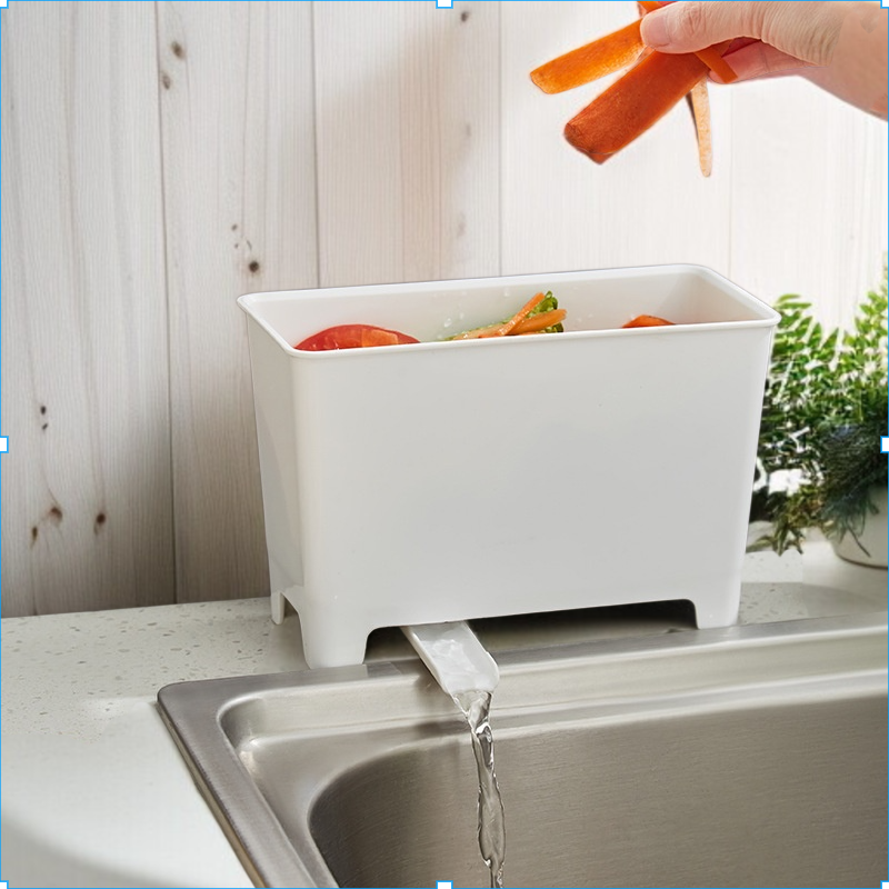 Kuchyňský odpadkový koš vedle dřezu na odkapávající kuchyňský odpad