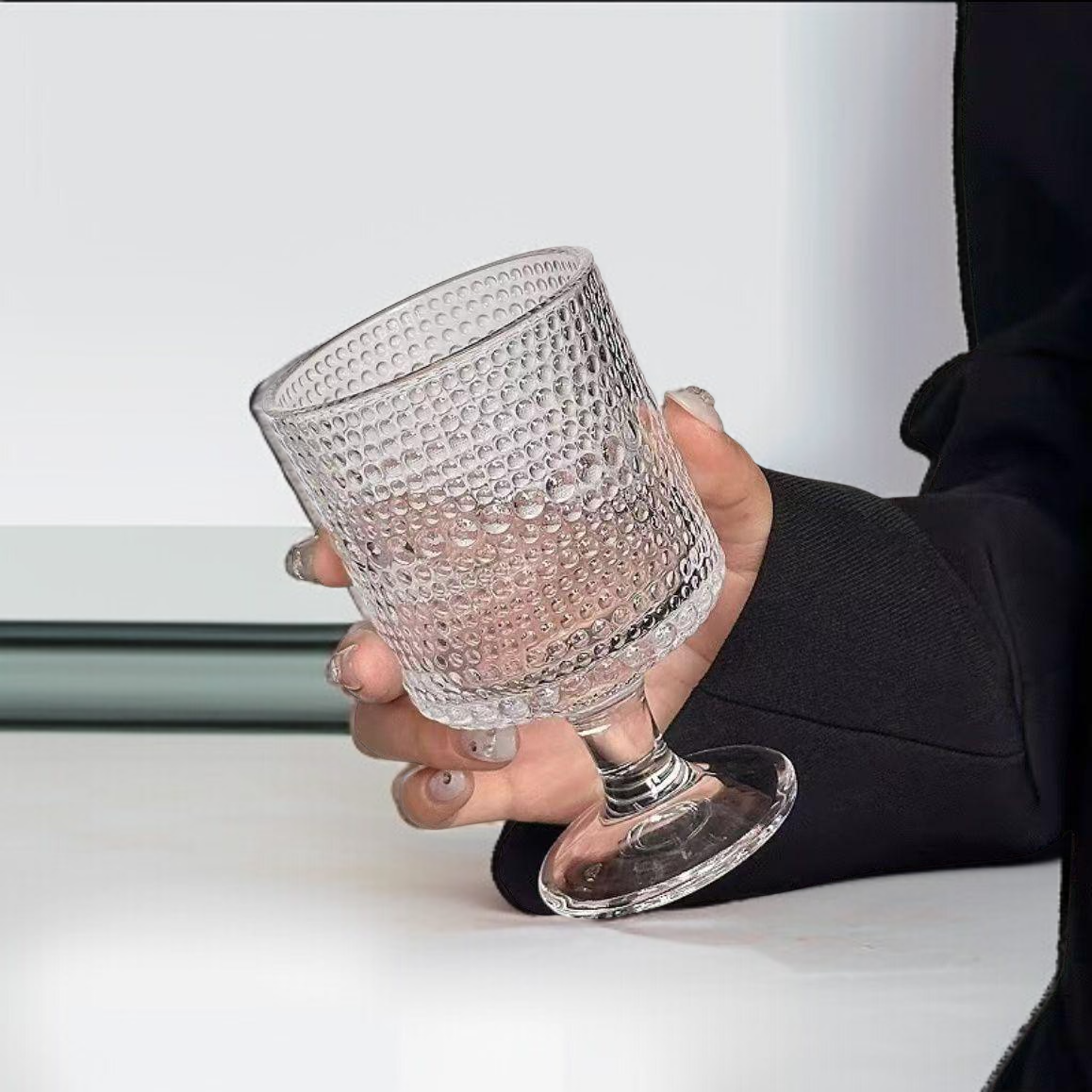 レトロなレリーフが美しい脚付きグラスの正面写真