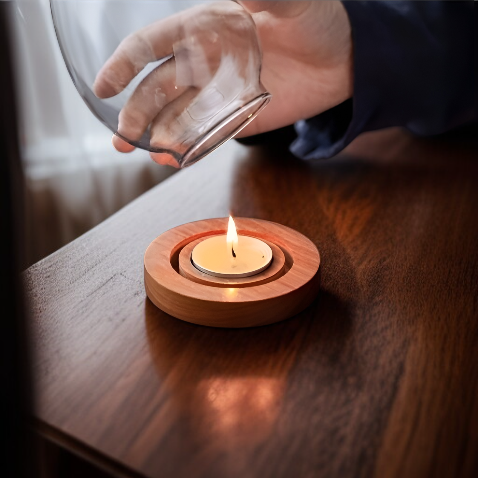 Dekorativer Glas-Kerzenhalter neben Blumen